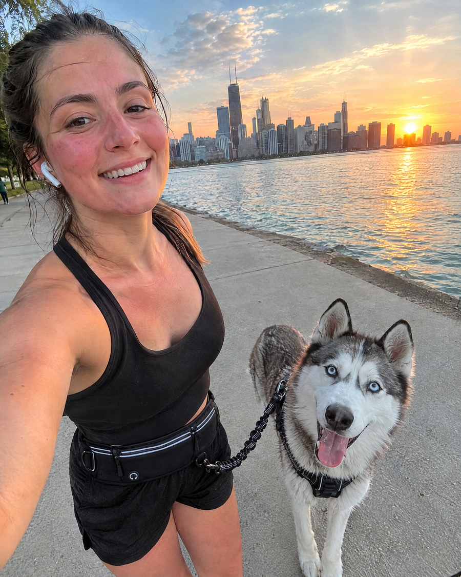Runner selfie with her husky on a lakefront path at sunrise