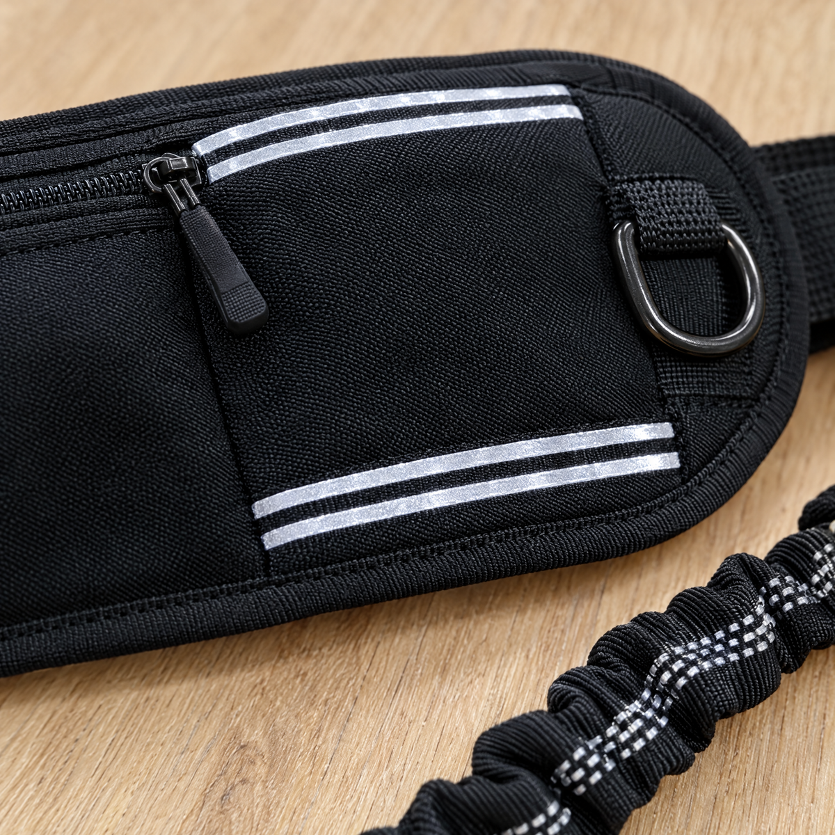 Close-up of the black belt fabric, zip, reflective strips and D-ring